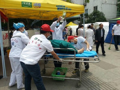 蒙牛志愿者協助醫護人員將傷者從救護車運送至醫院